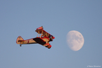 Der Doppeldecker fliegt vor dem Mond